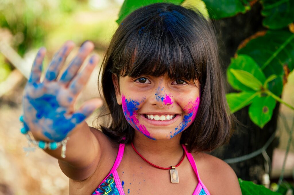 little indian girl painted her face with pink and blue colors